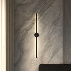 a bathroom with marble walls and flooring next to a black towel rack on the wall