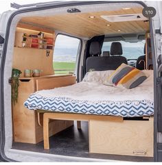 the interior of a van with a bed in it