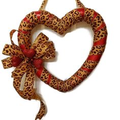 a heart shaped wreath with leopard print and red ribbon