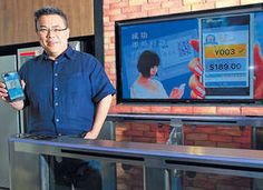 a man standing in front of a tv holding up a cell phone and an ipod