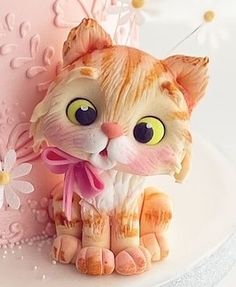 a cat figurine sitting on top of a cake