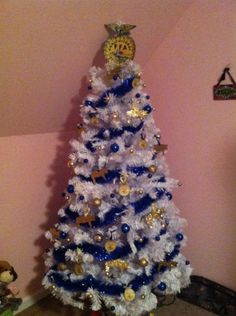 a white christmas tree with blue and gold decorations