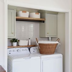 a washer and dryer in a small room with cabinets above the washer