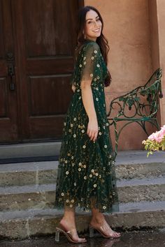 a woman in a green dress standing on steps