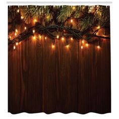 christmas lights are hanging from the branches of a pine tree on a wooden background with wood planks