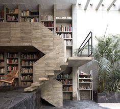 the stairs are made out of concrete and have bookshelves