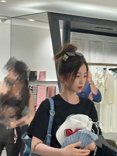 a woman is looking at her cell phone while she shops for clothes in a clothing store