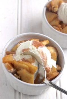 two bowls filled with dessert and ice cream on top of a white wooden table next to each other