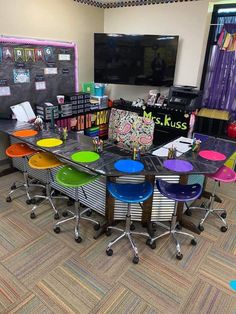 an empty classroom with colorful chairs and desks