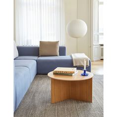 a living room filled with furniture and a blue couch in front of a white window