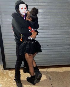 a man and woman dressed up as the joker and clown kiss each other on the cheek