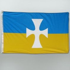 a flag with a cross on it hanging from the side of a wall in front of a gray background