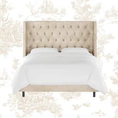 an upholstered bed with white linens and buttons on the headboard is shown