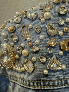 the back of a jean jacket with pearls and jewels on it