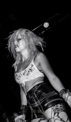 black and white photograph of a woman in punk clothing with her hands on her hips