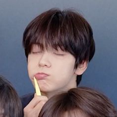 a man brushing his teeth while another woman looks on