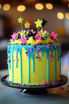 a colorful cake with stars and sprinkles on it sitting on a table