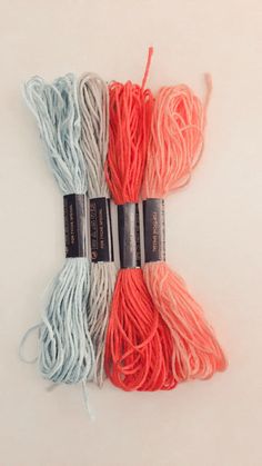 three skeins of yarn on a white surface