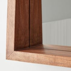 a wooden shelf with a mirror above it