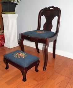 a wooden chair and footstool with blue upholstered cushion on the floor