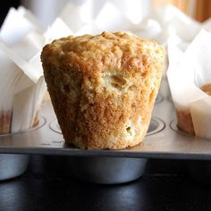 a muffin sitting on top of a metal pan next to other muffins