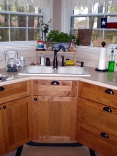 a kitchen with wooden cabinets and white counter tops is pictured in this image, the sink has no faucet or faucets on it