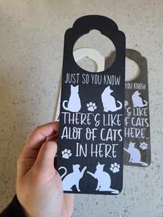 someone holding up a door hanger that says, just so you know there's like all of cats here in here