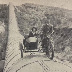 an old photo of two people riding on a motorcycle and side car in the road