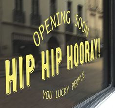 a sign on the side of a building that says, opening soon hip hooray you lucky people