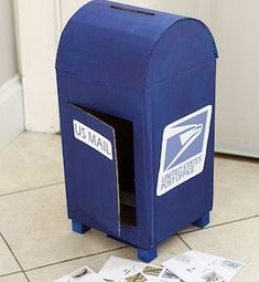 a blue mailbox sitting on the floor next to a door with some papers sticking out of it