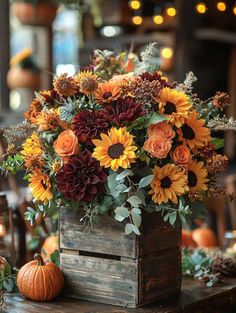 a wooden box filled with lots of flowers and greenery on top of a table