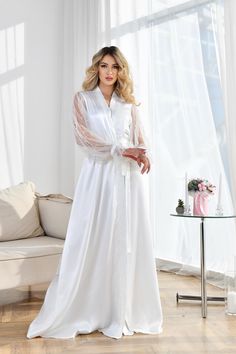 White bride robe for wedding day  is made of high-qualiry silk satin. It has long wide sleeves with pearls made of lace and wide belt.   Pearl bridal robe When you have one of the most important wedding day in your life, everything should be perfect! You probably planned every minute of this day and now you are ready to make it real. The perfect day starts from the very morning which will be remembered every time you will look at your photos. Mother of the bride robe Bridal robe for bride for we Wedding Night Satin Robe With Lace Sleeves, Elegant Robe With Lace Sleeves For Wedding Night, Elegant Wedding Night Gown With Lace Sleeves, Satin Long Sleeve Dresses For Mother Of The Bride, Elegant Robe With Lace Long Sleeves, Satin Wedding Gown With Lace Trim, Satin Robe With Lace Trim And Long Sleeves, Long Sleeve Satin Robe With Lace Trim, Elegant Long Sleeve Robe For Bridesmaids