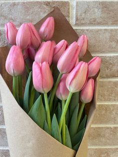 a bouquet of pink tulips in a brown paper bag