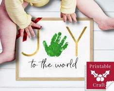 a baby's handprint is displayed in front of a sign that says joy to the world