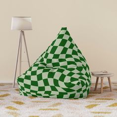 a green and white bean bag chair sitting on top of a rug next to a lamp