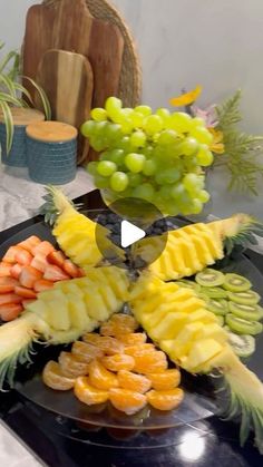 the fruit platter is made up of pineapples, oranges and grapes