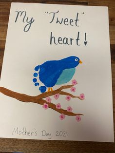 a blue bird sitting on top of a tree branch next to a sign that says, my tweet heart