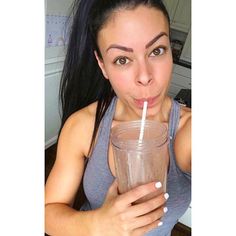 a woman holding a glass with a straw in it