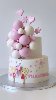 a three tiered cake with balloons and stars on the top is decorated in pink and white