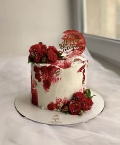 a red and white birthday cake with roses on it