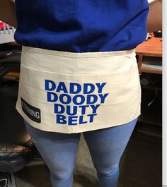 a person wearing an apron with the words daddy doody duty belt printed on it