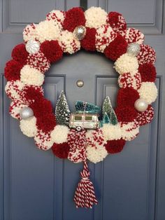 a red and white christmas wreath on a door