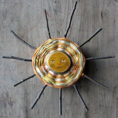 a yellow and silver object on top of a wooden table with sticks sticking out of it