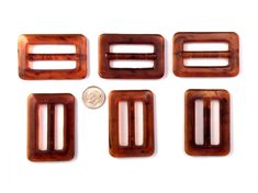 four wooden clips are shown with one penny