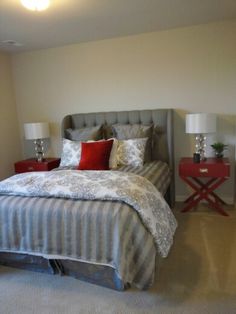 a bedroom with a bed, nightstands and two lamps on either side of the bed