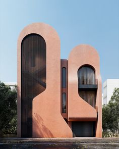 an architecturally designed pink building with two large round windows on the front and side