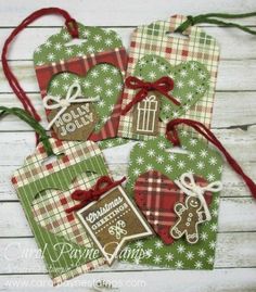 three tags with christmas designs on them are hanging from red ribbon and green plaid fabric