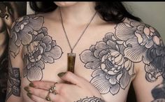 a woman with tattoos on her chest holding an object