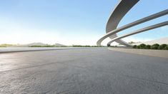 an empty parking lot in front of a building with curved concrete walls and trees on either side