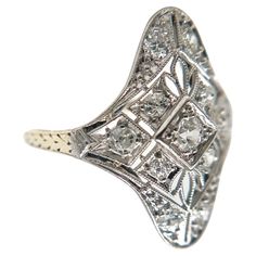 This antique diamond ring was handcrafted sometime during the Edwardian design period (1900-1920). The 14K white gold setting features intricate filigree, precise milgrain accents, and beautiful hand engravings. Crafted with meticulous attention to detail, this ring showcases a radiant shield design adorned with eleven dazzling accent diamonds. Each diamond sparkles with brilliance, effortlessly catching the light and illuminating your every movement. With a total carat weight of 0.5, these diam Edwardian Design, Antique Diamond Ring, Shield Ring, Antique Diamond Rings, Shield Design, Antique Diamond, Delicate Details, Hand Engraving, Cocktail Rings